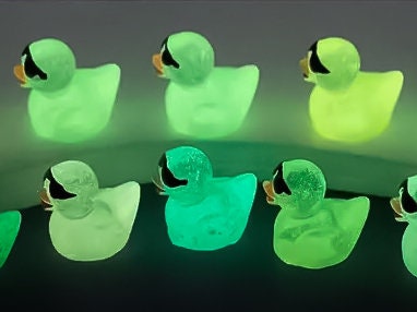 Glow-in-the-dark shoe charms shaped like cool ducks wearing sunglasses. These vibrant ducks come to life in the dark, glowing in neon shades while their tiny black sunglasses add a playful, stylish touch to your shoes.