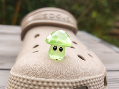 Glow-in-the-dark mushroom charms on a pair of shoes shoes. These luminous accessories add a magical, whimsical touch to your footwear, perfect for customizing with a unique forest-inspired design that glows beautifully in the dark.