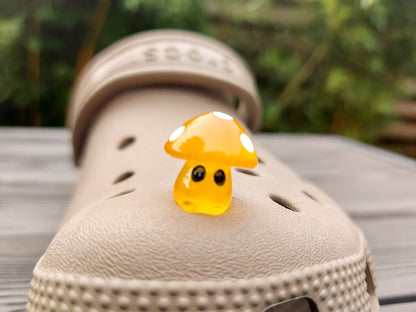 Glow-in-the-dark mushroom charms on a pair of shoes shoes. These luminous accessories add a magical, whimsical touch to your footwear, perfect for customizing with a unique forest-inspired design that glows beautifully in the dark.
