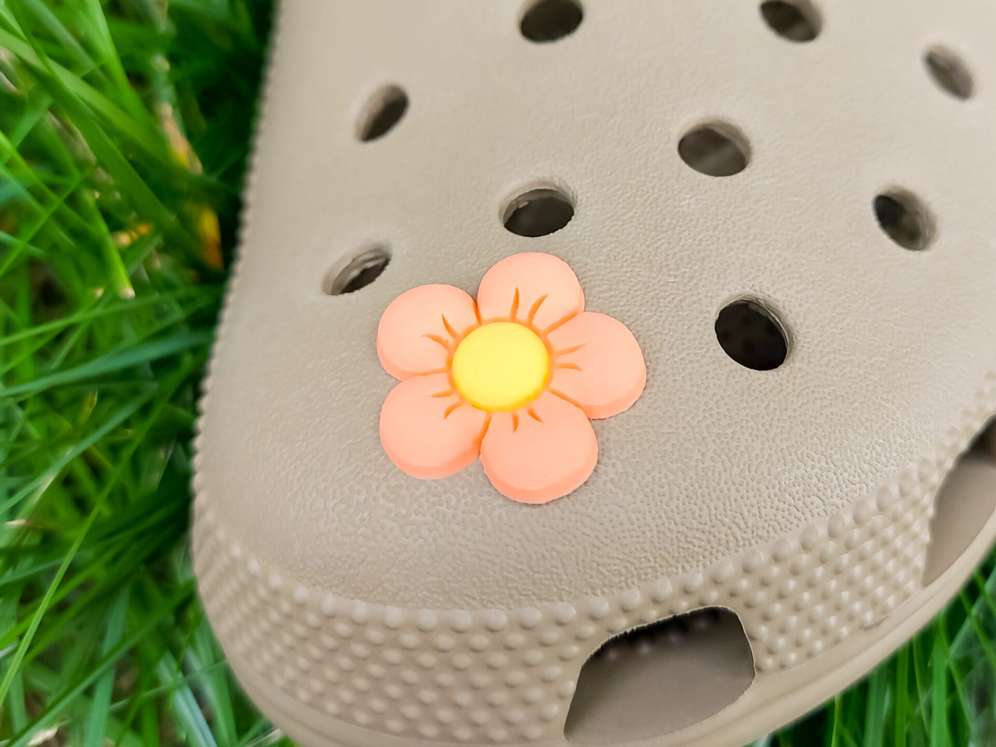 A cluster of vibrant cosmos flower charms decorates a shoes shoe, with each charm showcasing delicate petals in shades of pink, white, and purple. The intricate details of the flowers mimic real cosmos blooms, with soft gradients and textured centers