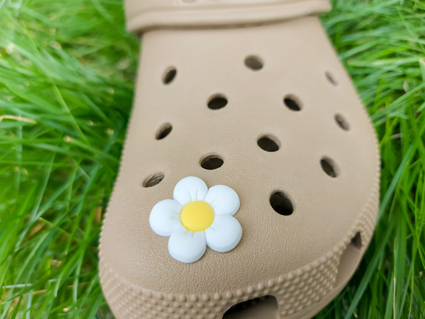 A cluster of vibrant cosmos flower charms decorates a shoes shoe, with each charm showcasing delicate petals in shades of pink, white, and purple. The intricate details of the flowers mimic real cosmos blooms, with soft gradients and textured centers
