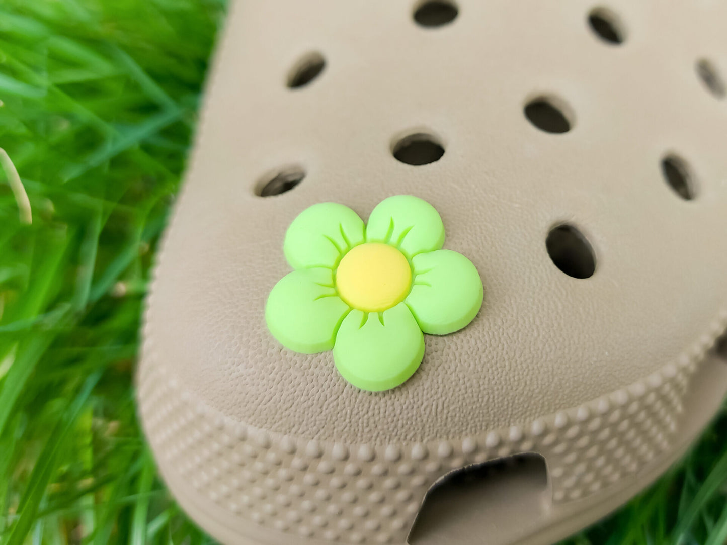 A cluster of vibrant cosmos flower charms decorates a shoes shoe, with each charm showcasing delicate petals in shades of pink, white, and purple. The intricate details of the flowers mimic real cosmos blooms, with soft gradients and textured centers