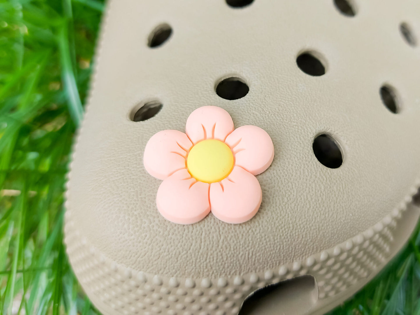 A cluster of vibrant cosmos flower charms decorates a shoes shoe, with each charm showcasing delicate petals in shades of pink, white, and purple. The intricate details of the flowers mimic real cosmos blooms, with soft gradients and textured centers