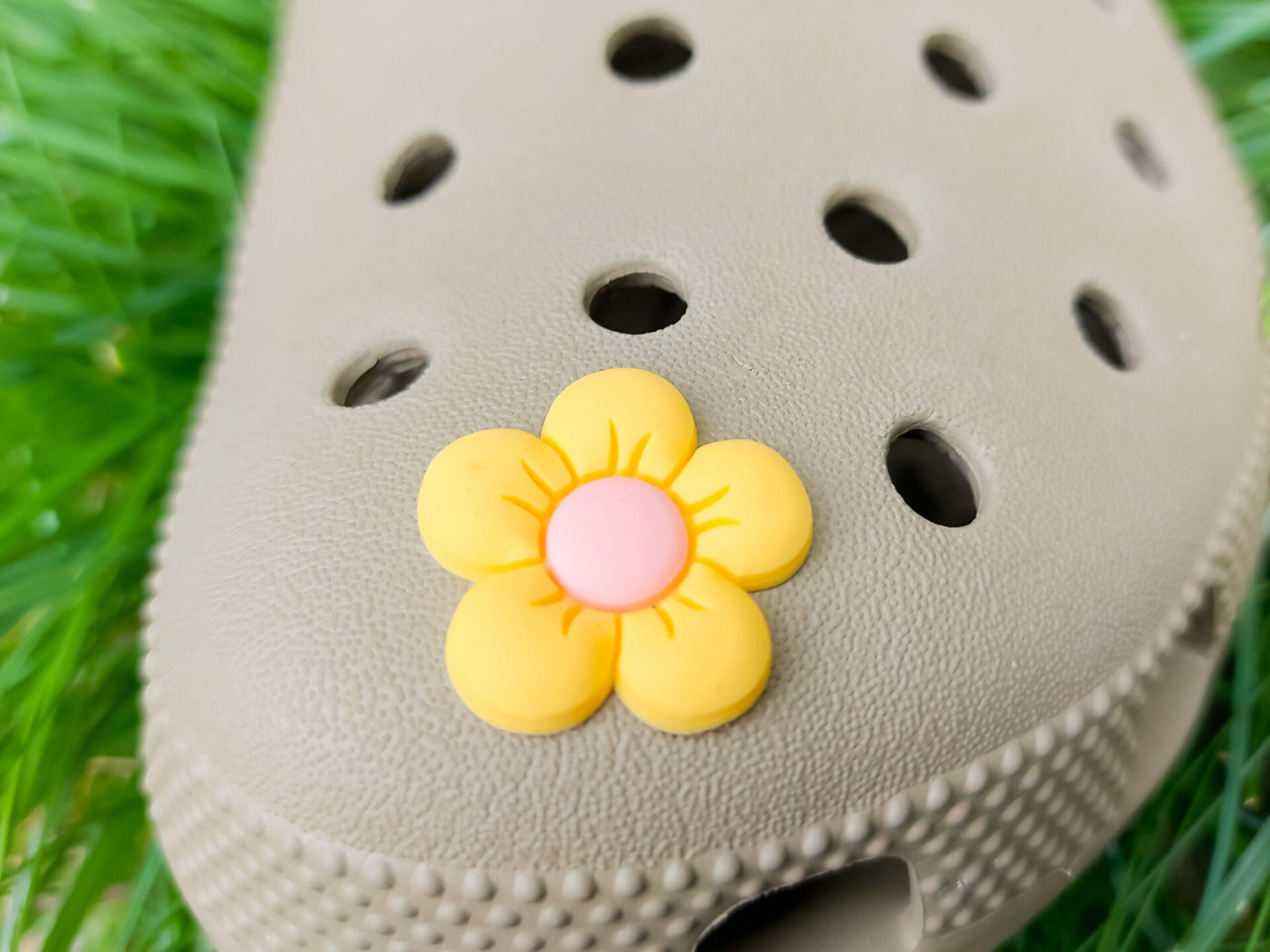 A cluster of vibrant cosmos flower charms decorates a shoes shoe, with each charm showcasing delicate petals in shades of pink, white, and purple. The intricate details of the flowers mimic real cosmos blooms, with soft gradients and textured centers