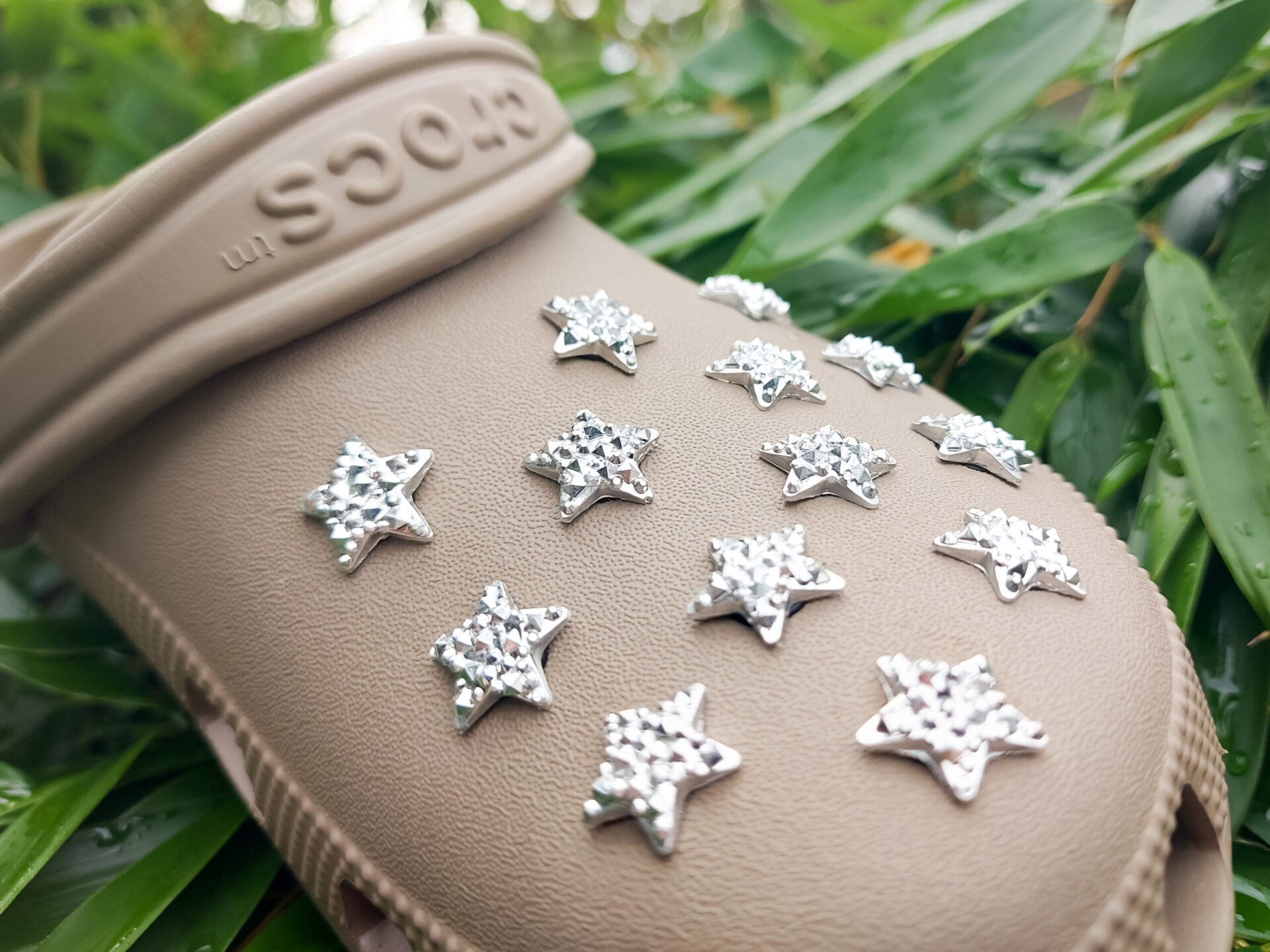 A set of crystal star-shaped charms for shoes, featuring sparkling, light-catching designs. The charms are arranged to showcase their dazzling look, with each star creating a celestial vibe perfect for adding a bit of shine and magic to any shoe.
