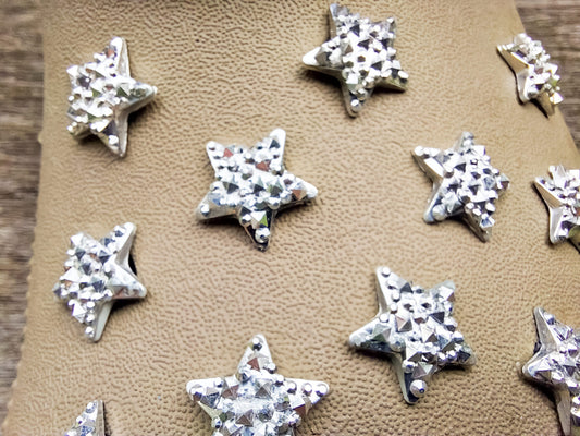 A set of crystal star-shaped charms for shoes, featuring sparkling, light-catching designs. The charms are arranged to showcase their dazzling look, with each star creating a celestial vibe perfect for adding a bit of shine and magic to any shoe.