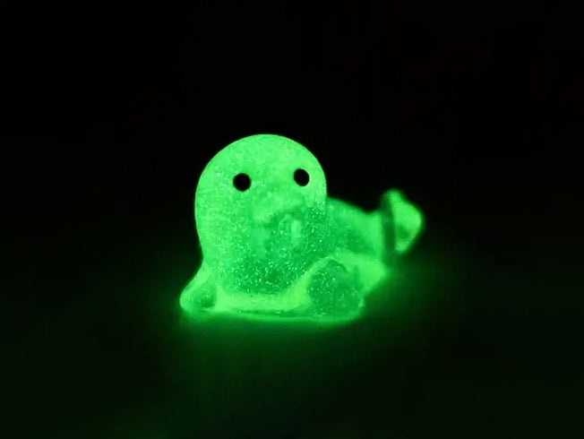 A yellow shoe shoe adorned with colorful glow-in-the-dark seal charms in shades of pink, blue, green, yellow, and purple, set against a natural background with blades of grass.