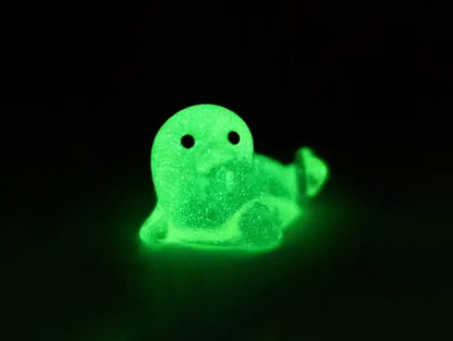 A yellow shoe shoe adorned with colorful glow-in-the-dark seal charms in shades of pink, blue, green, yellow, and purple, set against a natural background with blades of grass.