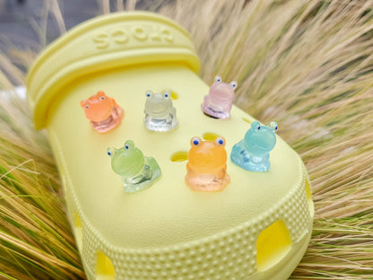 Glow-in-the-dark frog charms on a shoe shoe. These playful and luminous accessories add a fun, froggy touch to your footwear, making them perfect for customizing your shoes with a whimsical and adventurous vibe.