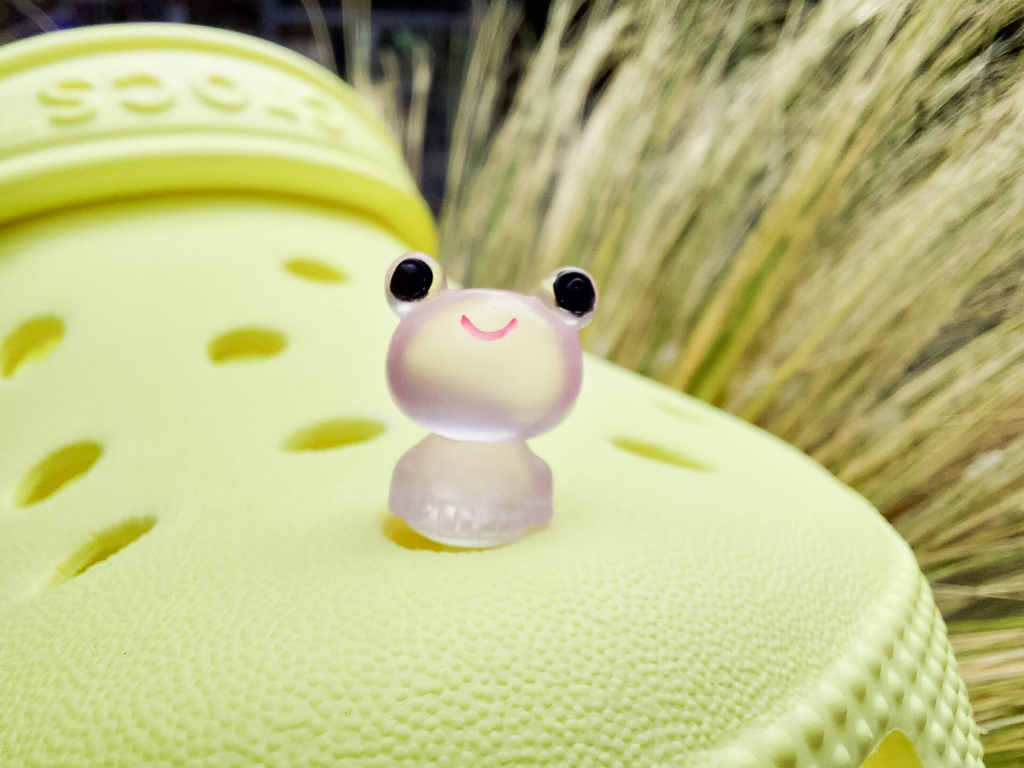 Glow-in-the-dark frog charms on a yellow shoes shoe. These playful and luminous accessories add a fun, froggy touch to your footwear, making them perfect for customizing your shoes with a whimsical and adventurous vibe.