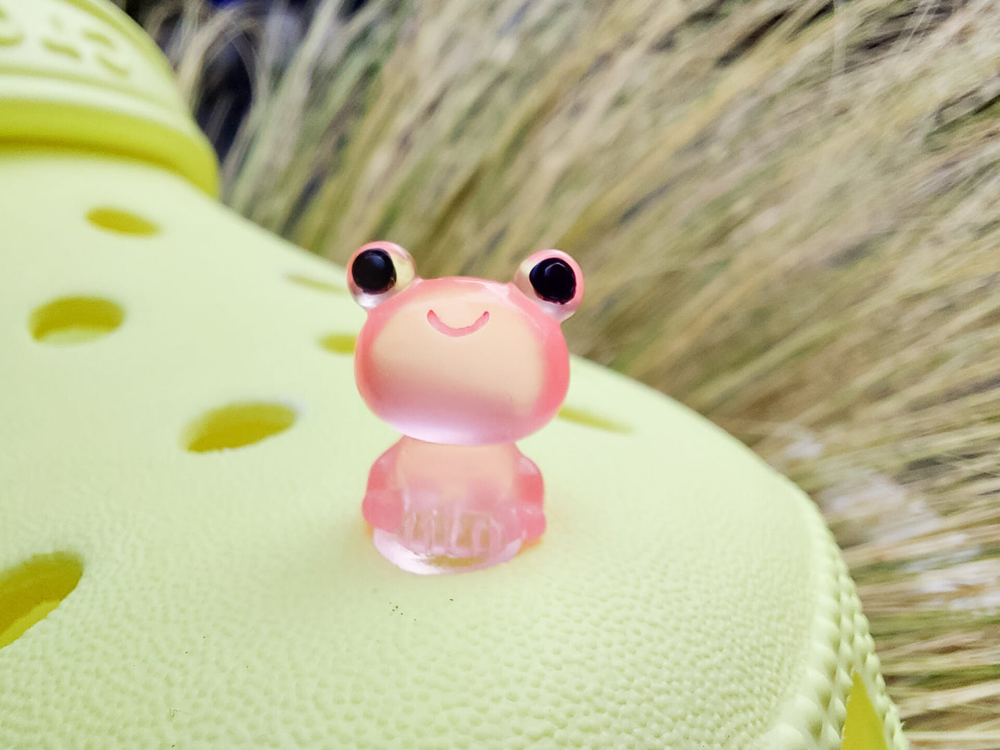 Glow-in-the-dark frog charms on a yellow shoes shoe. These playful and luminous accessories add a fun, froggy touch to your footwear, making them perfect for customizing your shoes with a whimsical and adventurous vibe.