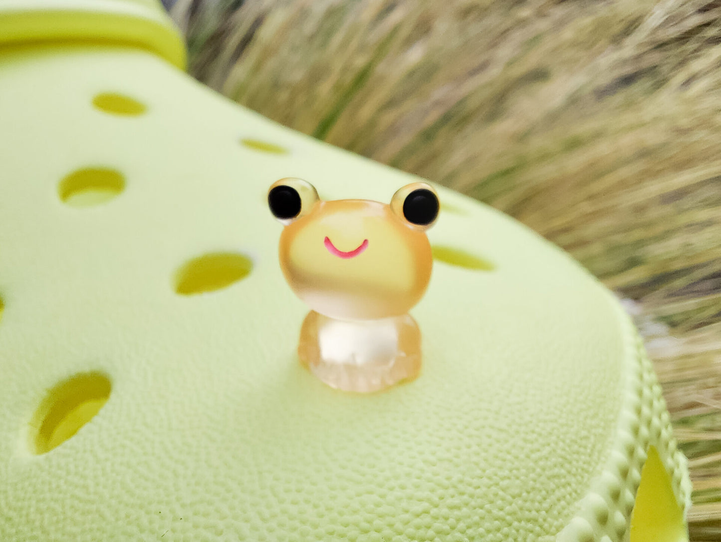 Glow-in-the-dark frog charms on a yellow shoes shoe. These playful and luminous accessories add a fun, froggy touch to your footwear, making them perfect for customizing your shoes with a whimsical and adventurous vibe.