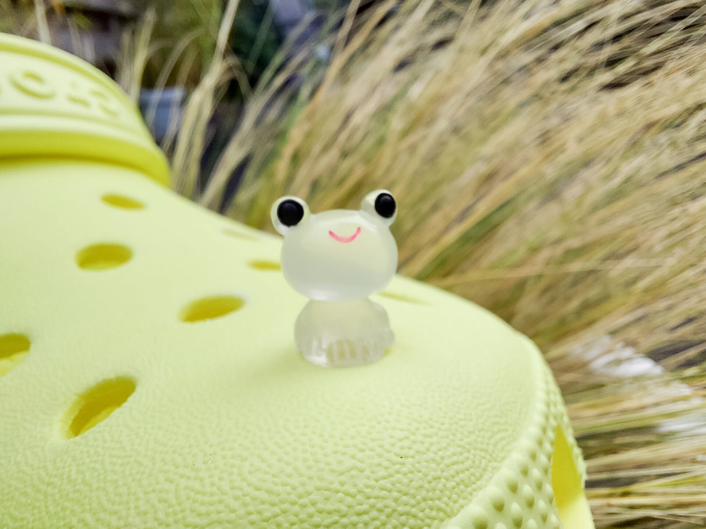 Glow-in-the-dark frog charms on a yellow shoes shoe. These playful and luminous accessories add a fun, froggy touch to your footwear, making them perfect for customizing your shoes with a whimsical and adventurous vibe.