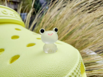 Glow-in-the-dark frog charms on a yellow shoes shoe. These playful and luminous accessories add a fun, froggy touch to your footwear, making them perfect for customizing your shoes with a whimsical and adventurous vibe.