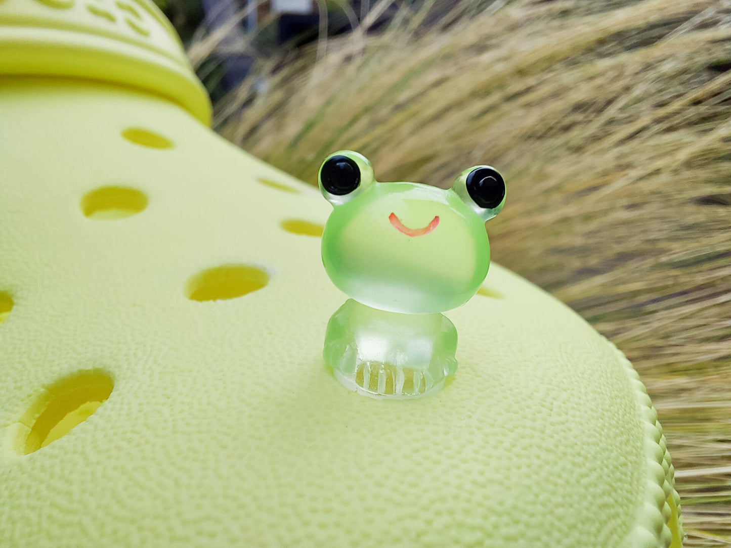 Glow-in-the-dark frog charms on a yellow shoes shoe. These playful and luminous accessories add a fun, froggy touch to your footwear, making them perfect for customizing your shoes with a whimsical and adventurous vibe.