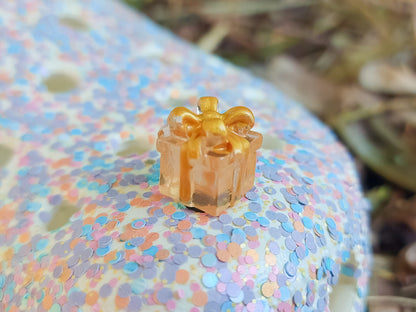 Glow in the dark christmas present charms on a colorful shoes shoe. It is a gift box with a big ribbon on top available in blue, pink, green, orange and peach. Xmas-themed perfect for the holidays.