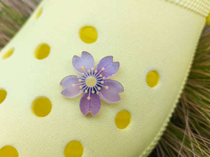 Glow-in-the-dark cherry blossom shoe charms in six colors—pink, dark pink, purple, blue, green, and orange—adding a soft, luminous effect to shoes with flower-themed elegance.