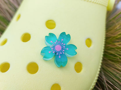 Glow-in-the-dark cherry blossom shoe charms in six colors—pink, dark pink, purple, blue, green, and orange—adding a soft, luminous effect to shoes with flower-themed elegance.