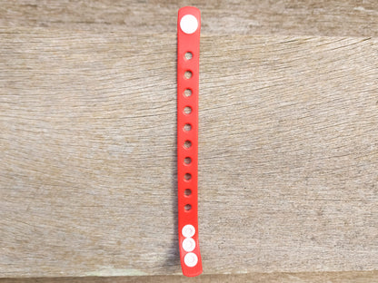 A flexible, adjustable bracelet with multiple charm slots, available in a range of vibrant colors for a personalized look.