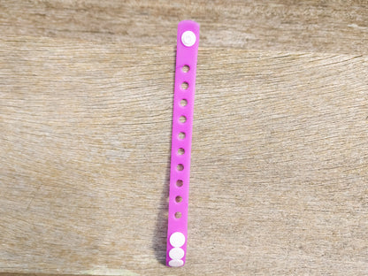 A flexible, adjustable bracelet with multiple charm slots, available in a range of vibrant colors for a personalized look.