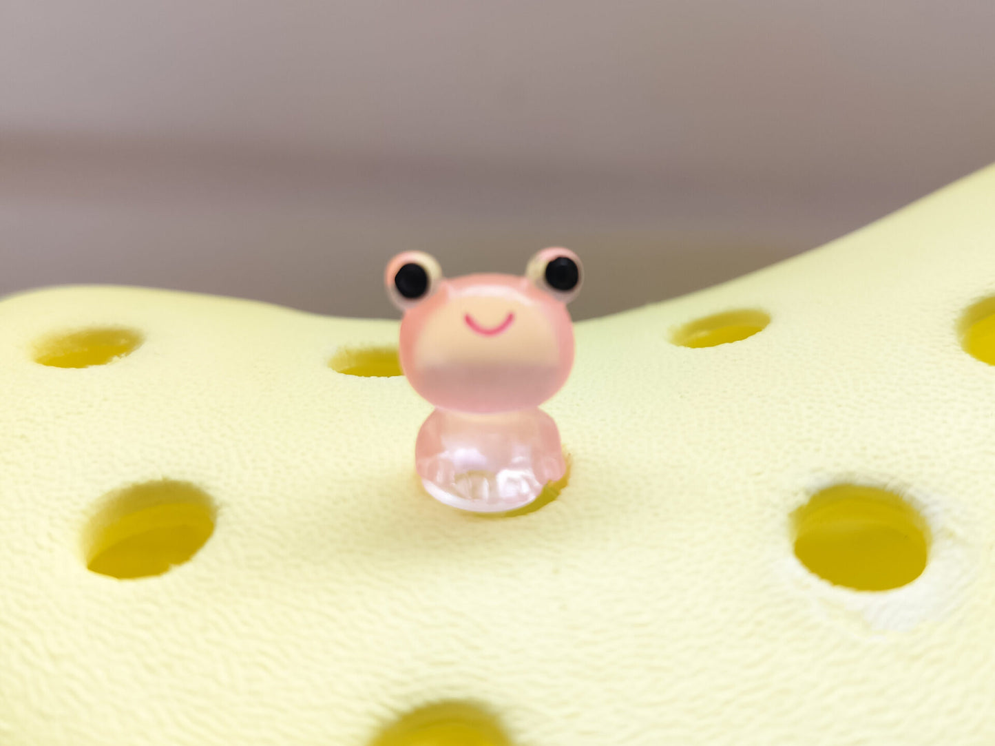Glow-in-the-dark frog charms on a yellow shoes shoe. These playful and luminous accessories add a fun, froggy touch to your footwear, making them perfect for customizing your shoes with a whimsical and adventurous vibe.