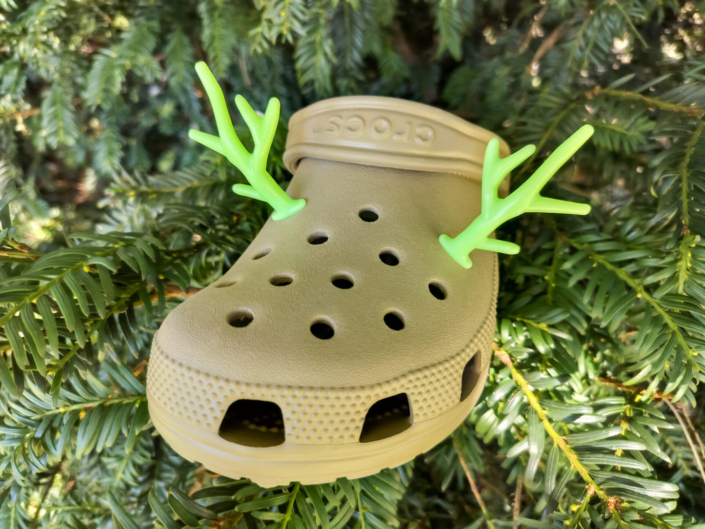 A pair of tan shoes decorated with red and gold reindeer antler charms, perched on a tree branch, perfect for holiday-themed footwear decorations. Available in multiple festive colors.