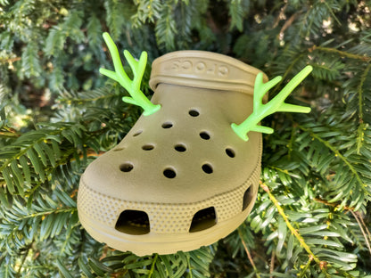 A pair of tan shoes decorated with red and gold reindeer antler charms, perched on a tree branch, perfect for holiday-themed footwear decorations. Available in multiple festive colors.