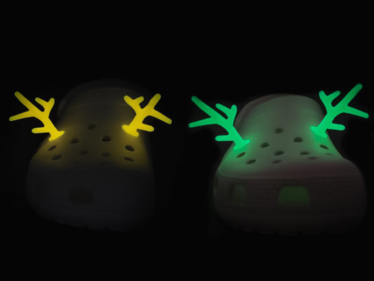 A pair of tan shoes decorated with red and gold reindeer antler charms, perched on a tree branch, perfect for holiday-themed footwear decorations. Available in multiple festive colors.