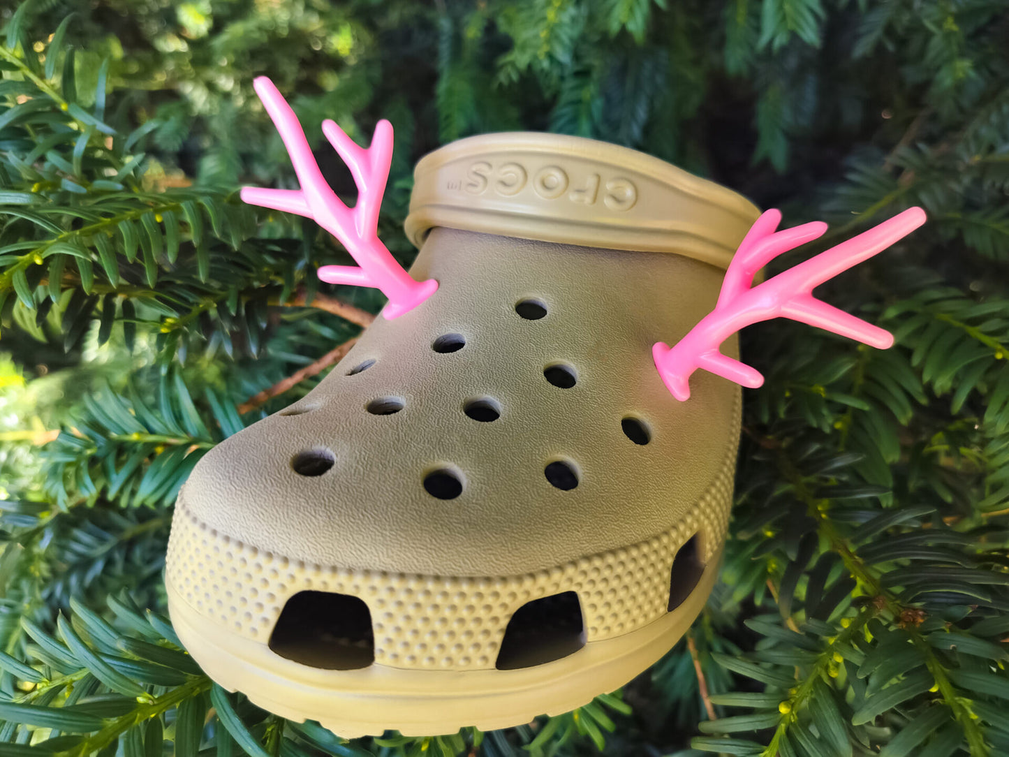 A pair of tan shoes decorated with red and gold reindeer antler charms, perched on a tree branch, perfect for holiday-themed footwear decorations. Available in multiple festive colors.