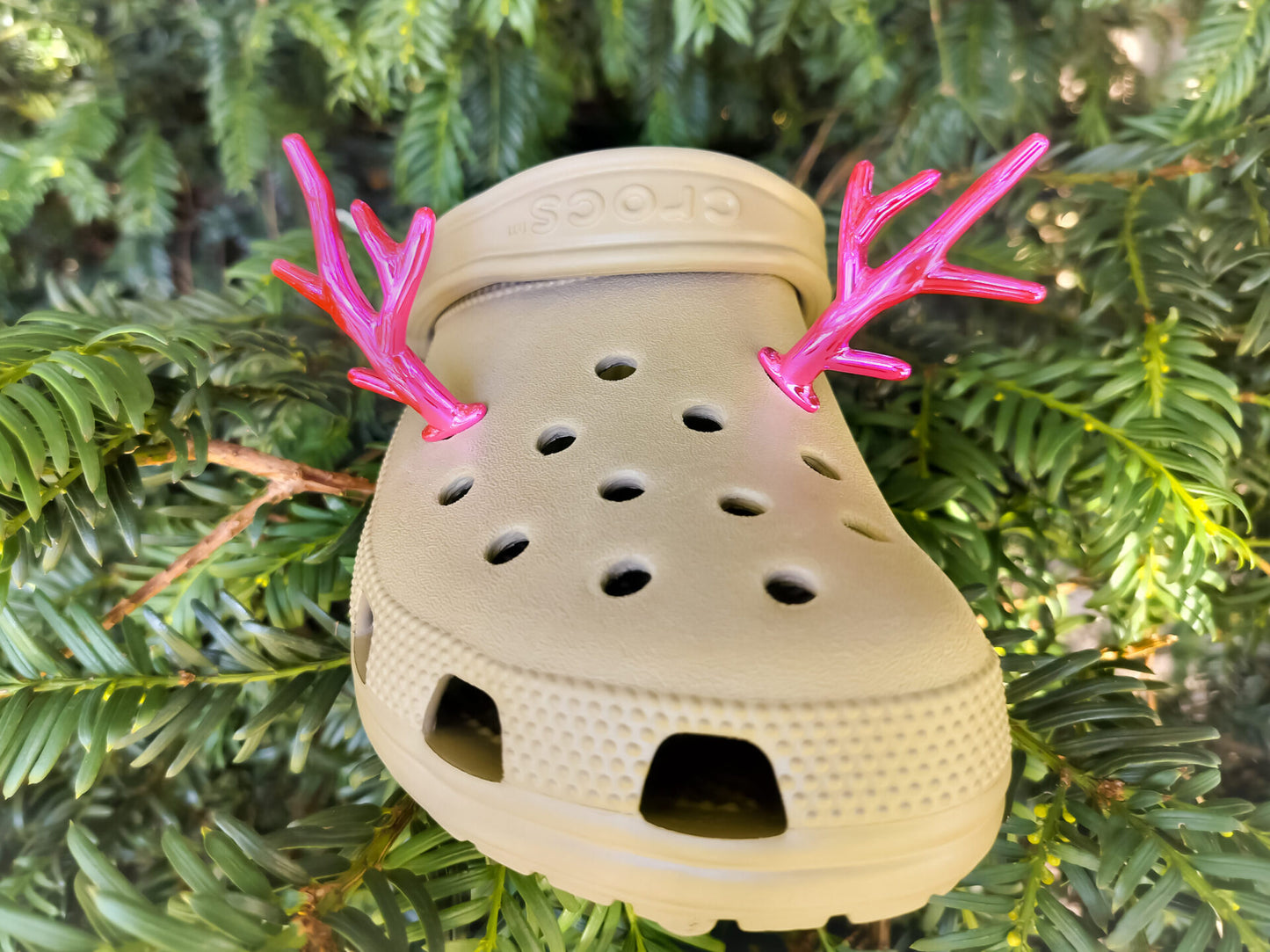 A pair of tan shoes decorated with red and gold reindeer antler charms, perched on a tree branch, perfect for holiday-themed footwear decorations. Available in multiple festive colors.