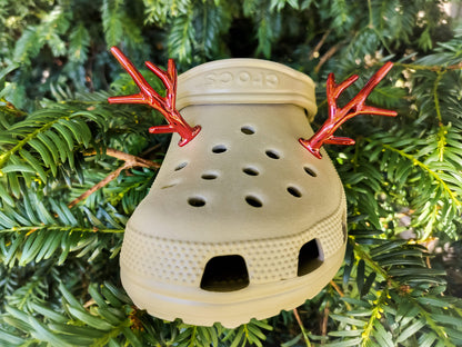 A pair of tan shoes decorated with red and gold reindeer antler charms, perched on a tree branch, perfect for holiday-themed footwear decorations. Available in multiple festive colors.