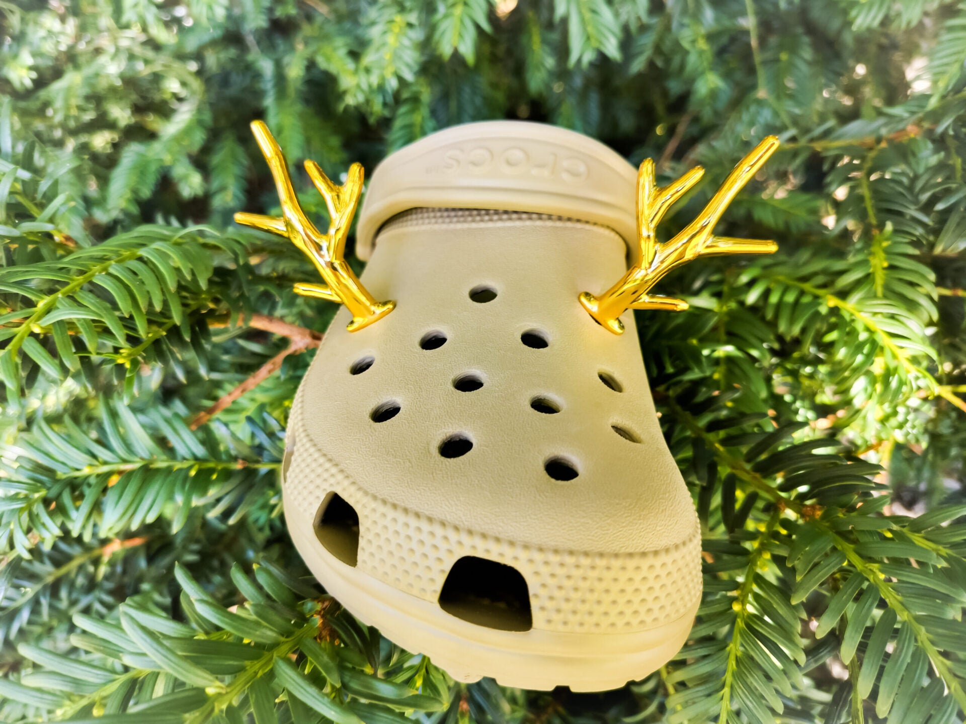 A pair of tan shoes decorated with red and gold reindeer antler charms, perched on a tree branch, perfect for holiday-themed footwear decorations. Available in multiple festive colors.