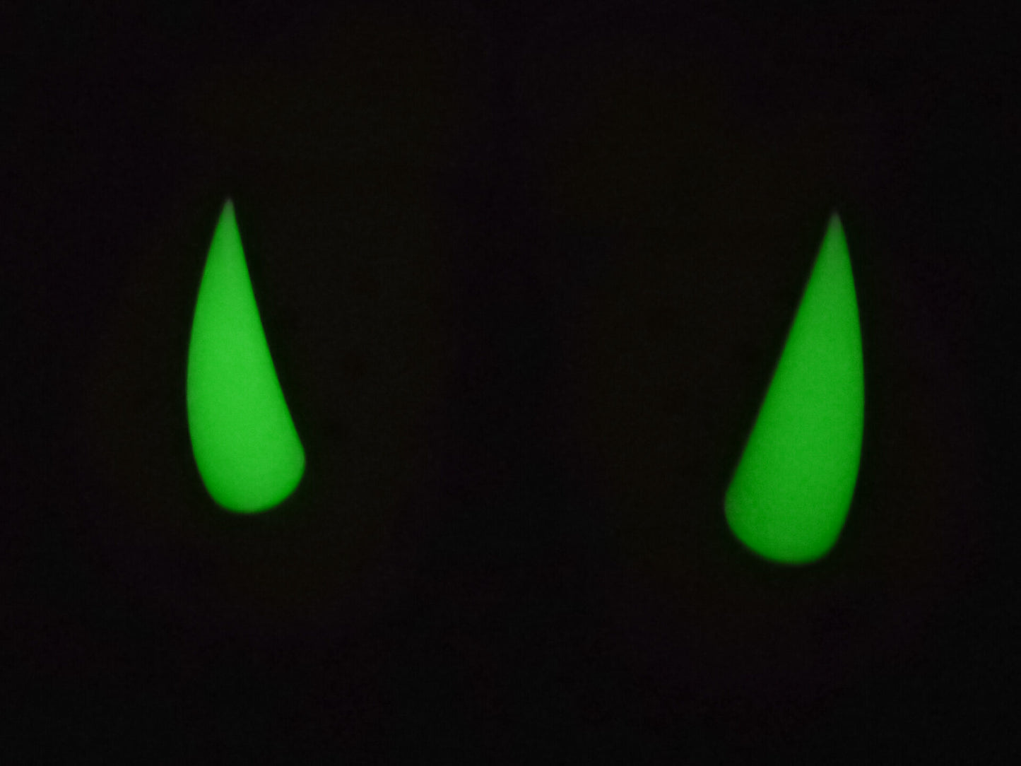 Pair of tan shoes with large glow-in-the-dark 3D printed rhino horn charms attached to the front, placed on a wooden surface.