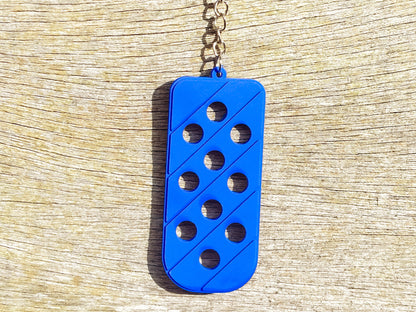 Three PVC keychains in pink, white, and blue with holes designed to hold shoe charms. Each keychain displays a unique set of charms, including candy-themed and colorful glitter charms, showcasing a playful and customizable accessory for charm lovers.