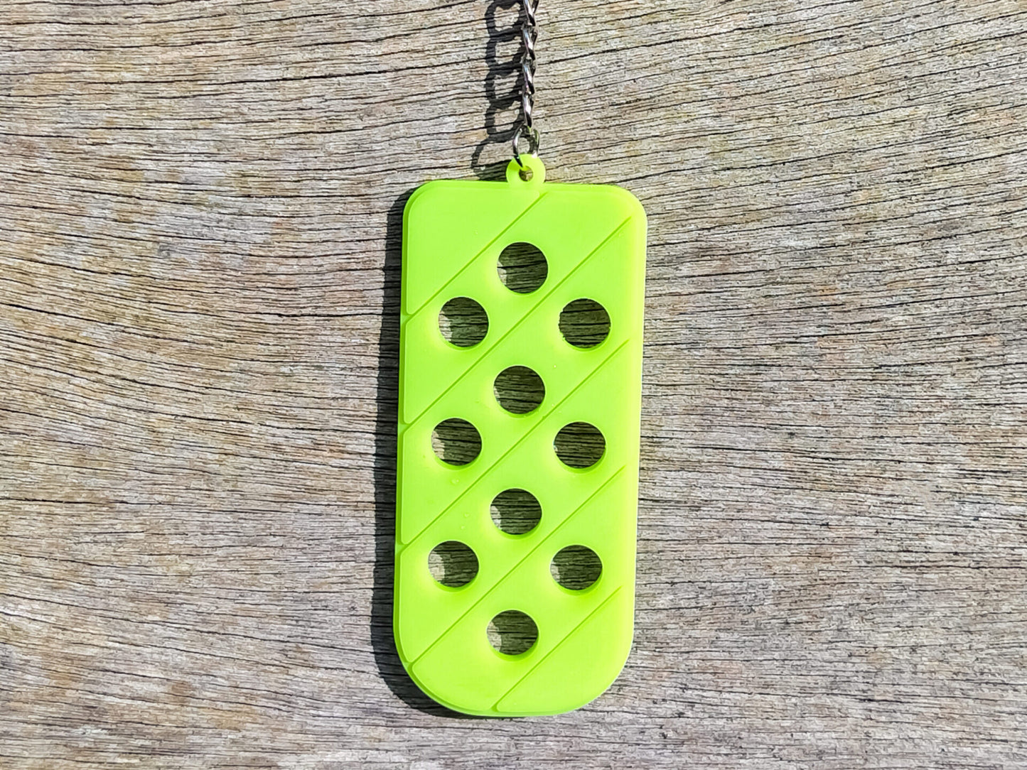 Three PVC keychains in pink, white, and blue with holes designed to hold shoe charms. Each keychain displays a unique set of charms, including candy-themed and colorful glitter charms, showcasing a playful and customizable accessory for charm lovers.