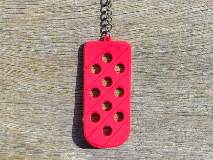 Three PVC keychains in pink, white, and blue with holes designed to hold shoe charms. Each keychain displays a unique set of charms, including candy-themed and colorful glitter charms, showcasing a playful and customizable accessory for charm lovers.