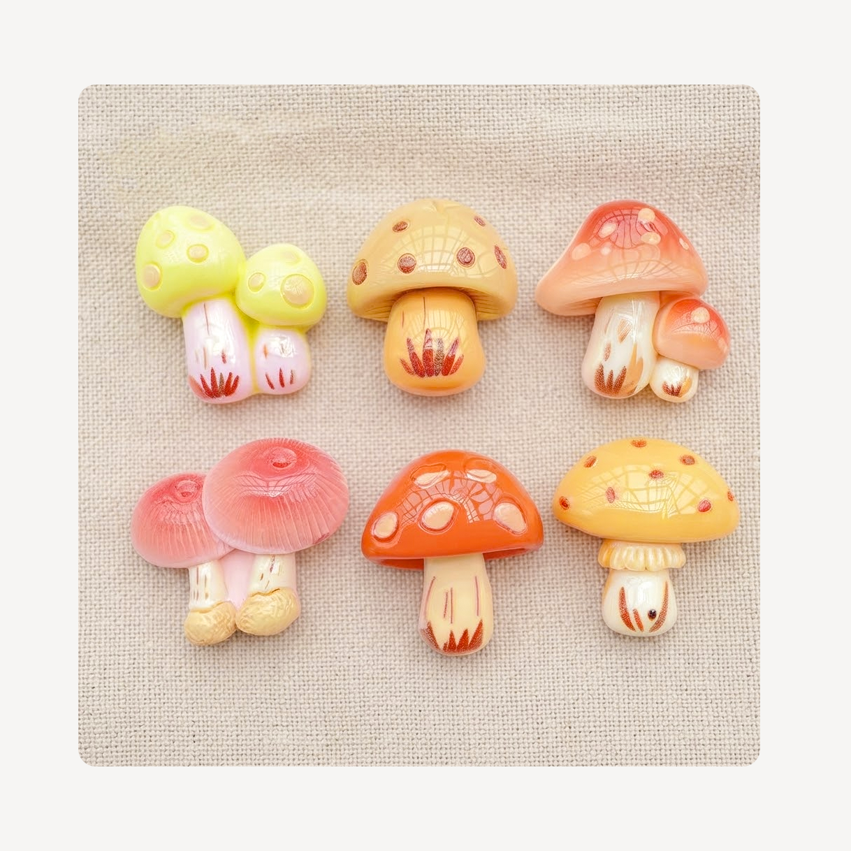 Six small mushroom-shaped clog charms arranged in two rows on a beige textured fabric background.