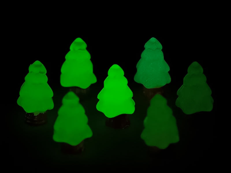 A beige shoes shoe adorned with small, glowing Christmas tree charms in a variety of soft colors, including yellow, pink, green, and blue. Each tree charm has a luminous effect, creating a festive and playful look.
