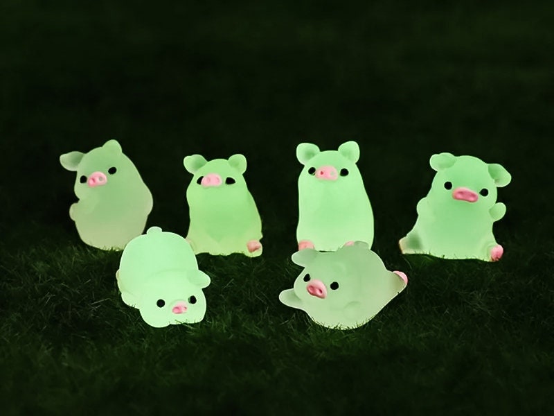 Set of glow-in-the-dark shoe charms featuring adorable pigs around a campfire on a shoe shoe. These playful accessories light up in the dark, adding a unique and whimsical touch to your footwear, perfect for personalizing your shoes.