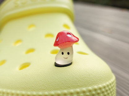 Glow-in-the-dark wild mushroom charms on a shoe shoe. These whimsical accessories light up in the dark, adding a magical and nature-inspired touch to your footwear. Perfect for customizing your shoes with a unique forest theme.