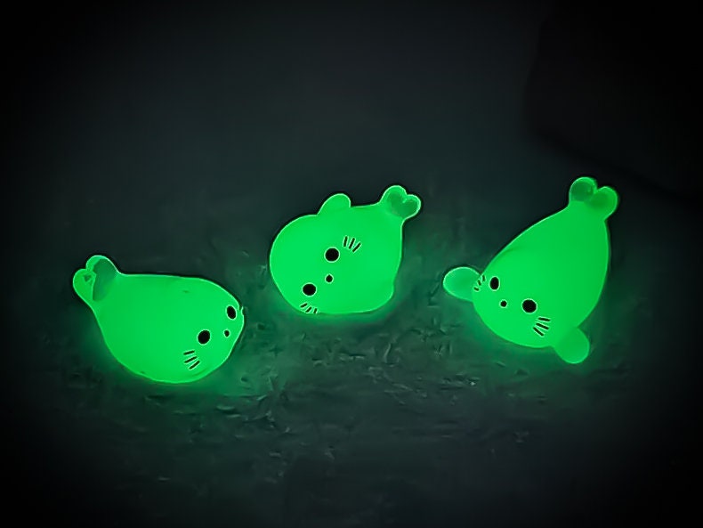Glow in the dark seal shoe charms on a pair of shoes shoes. The seals are made of resin and are each in different playful positions.