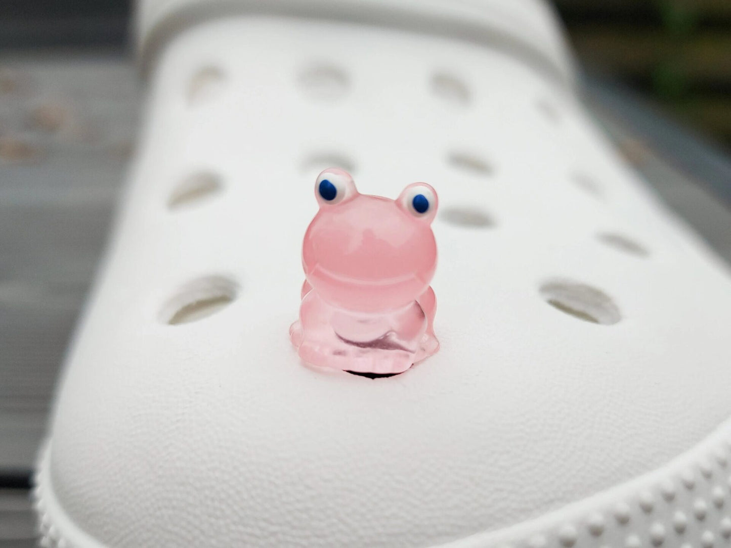 Glow-in-the-dark frog charms on a shoe shoe. These playful and luminous accessories add a fun, froggy touch to your footwear, making them perfect for customizing your shoes with a whimsical and adventurous vibe.