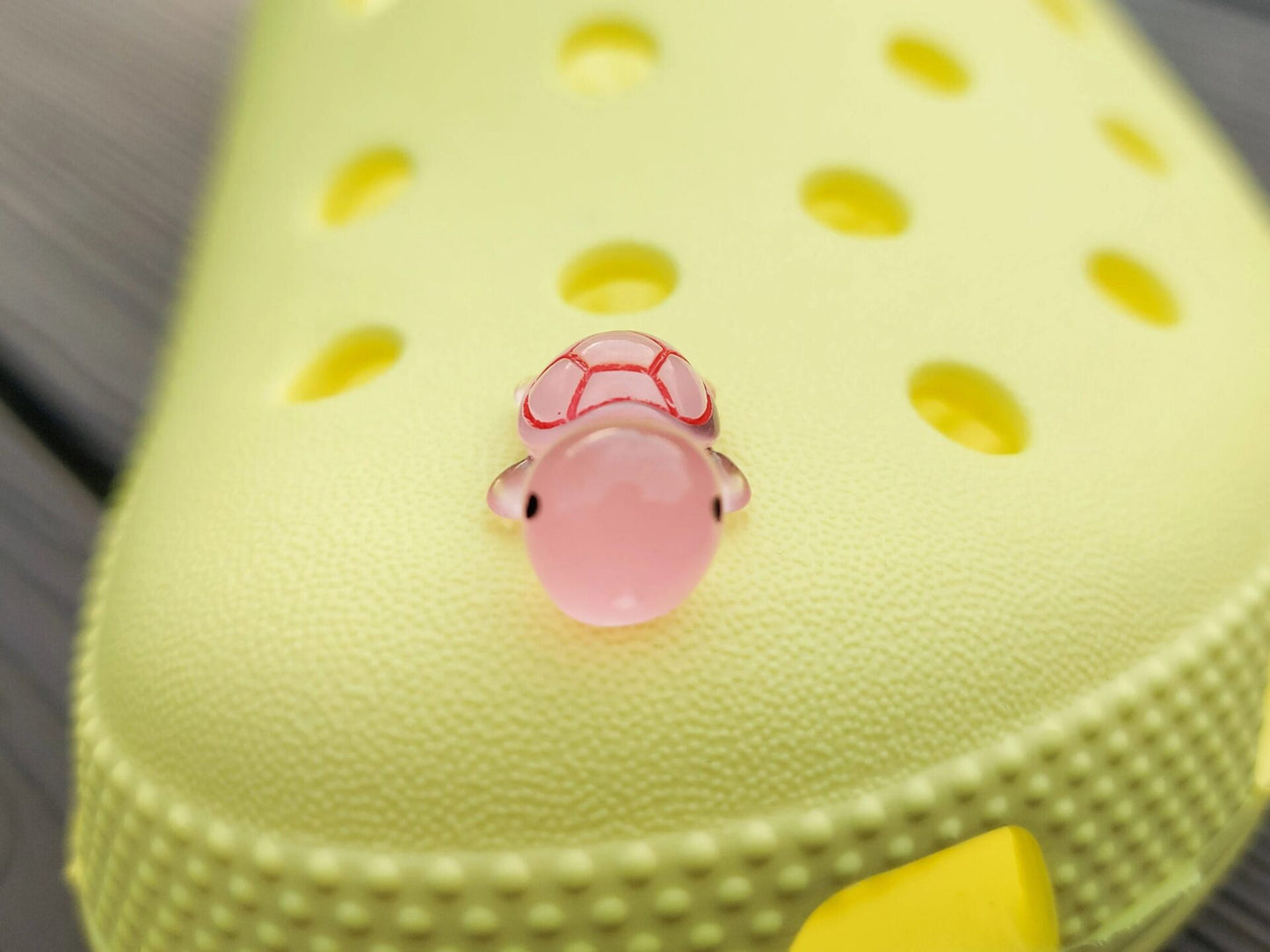 Glow-in-the-dark turtle charms on a shoe shoe. These adorable accessories, featuring detailed shell designs, bring a playful and luminous touch to the footwear, perfect for customizing your shoes with a fun, ocean-inspired look.