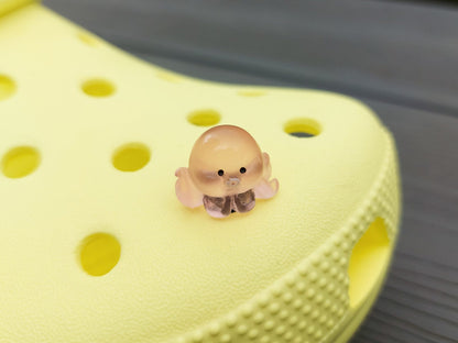 Glow in the dark octopus shoe charms on a pair of shoes shoes. Luminous charms in different colors.
