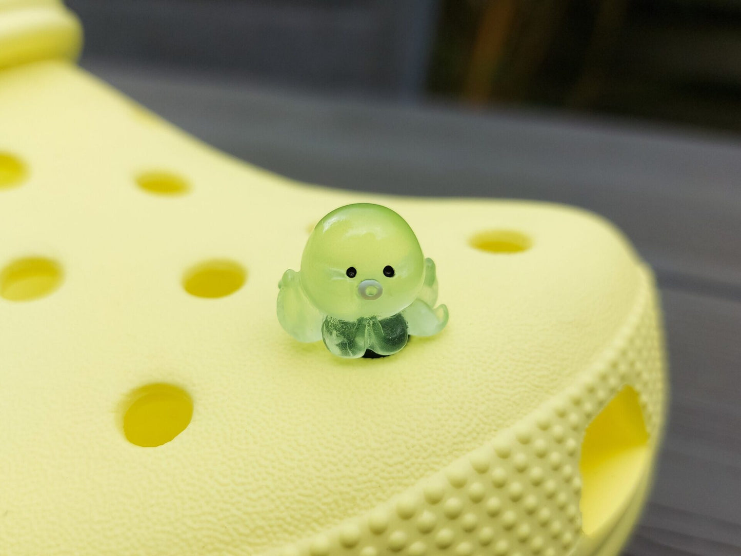 Glow in the dark octopus shoe charms on a pair of shoes shoes. Luminous charms in different colors.