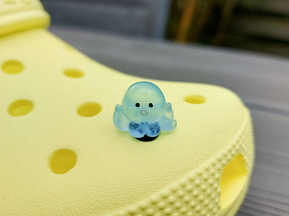 Glow in the dark octopus shoe charms on a pair of shoes shoes. Luminous charms in different colors.