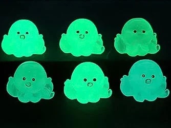 Glow in the dark octopus shoe charms on a pair of shoes shoes. Luminous charms in different colors.