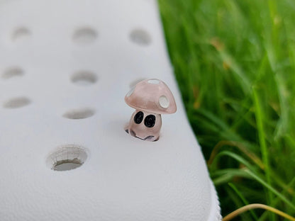 Glow-in-the-dark mushroom charms on a pair of shoes shoes. These luminous accessories add a magical, whimsical touch to your footwear, perfect for customizing with a unique forest-inspired design that glows beautifully in the dark.