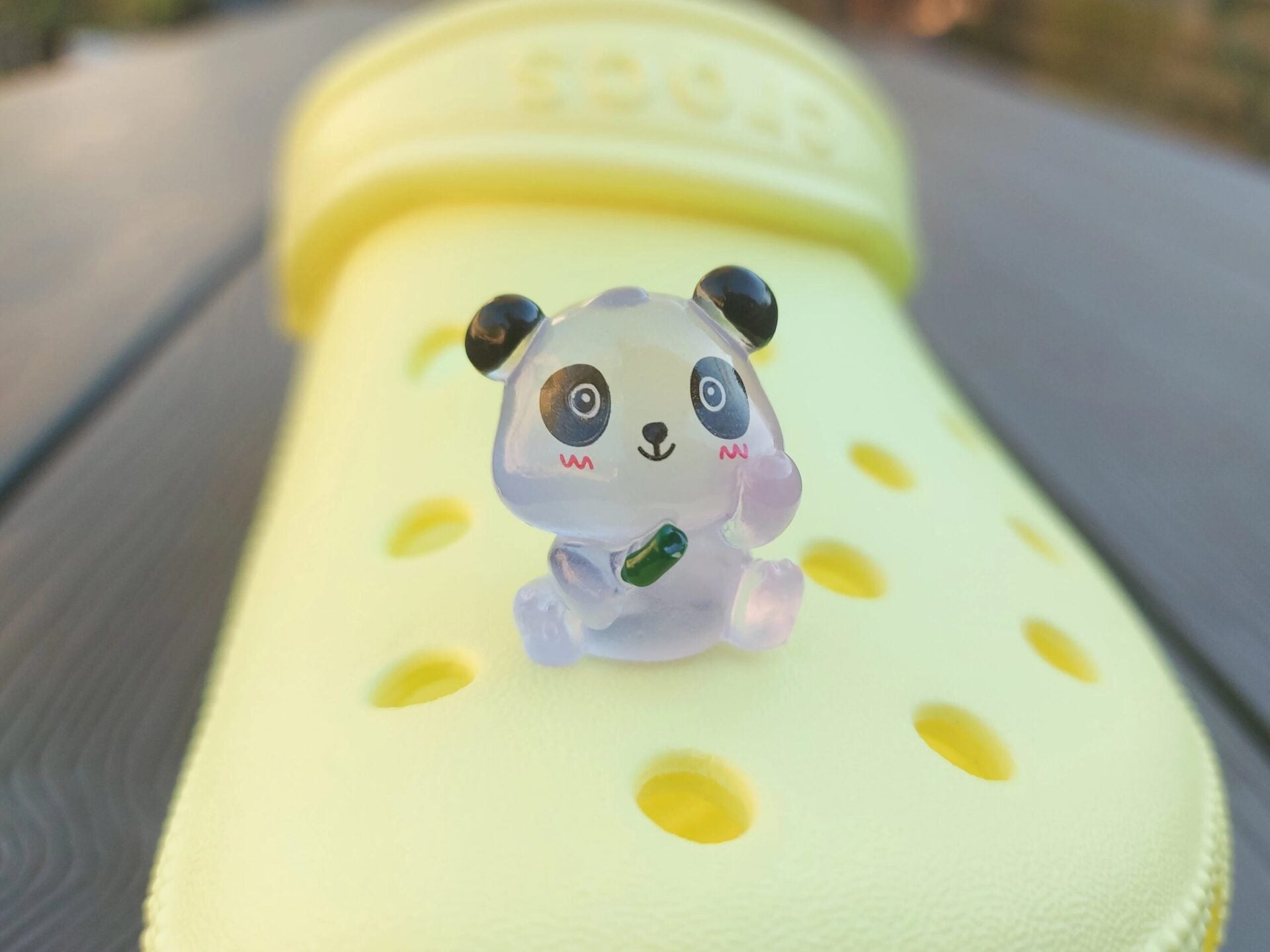 Set of glow in the dark panda shoe charms displayed on a shoe shoe. The charms feature small panda bears in various colors, with a glowing effect. These adorable accessories are designed to light up in the dark.