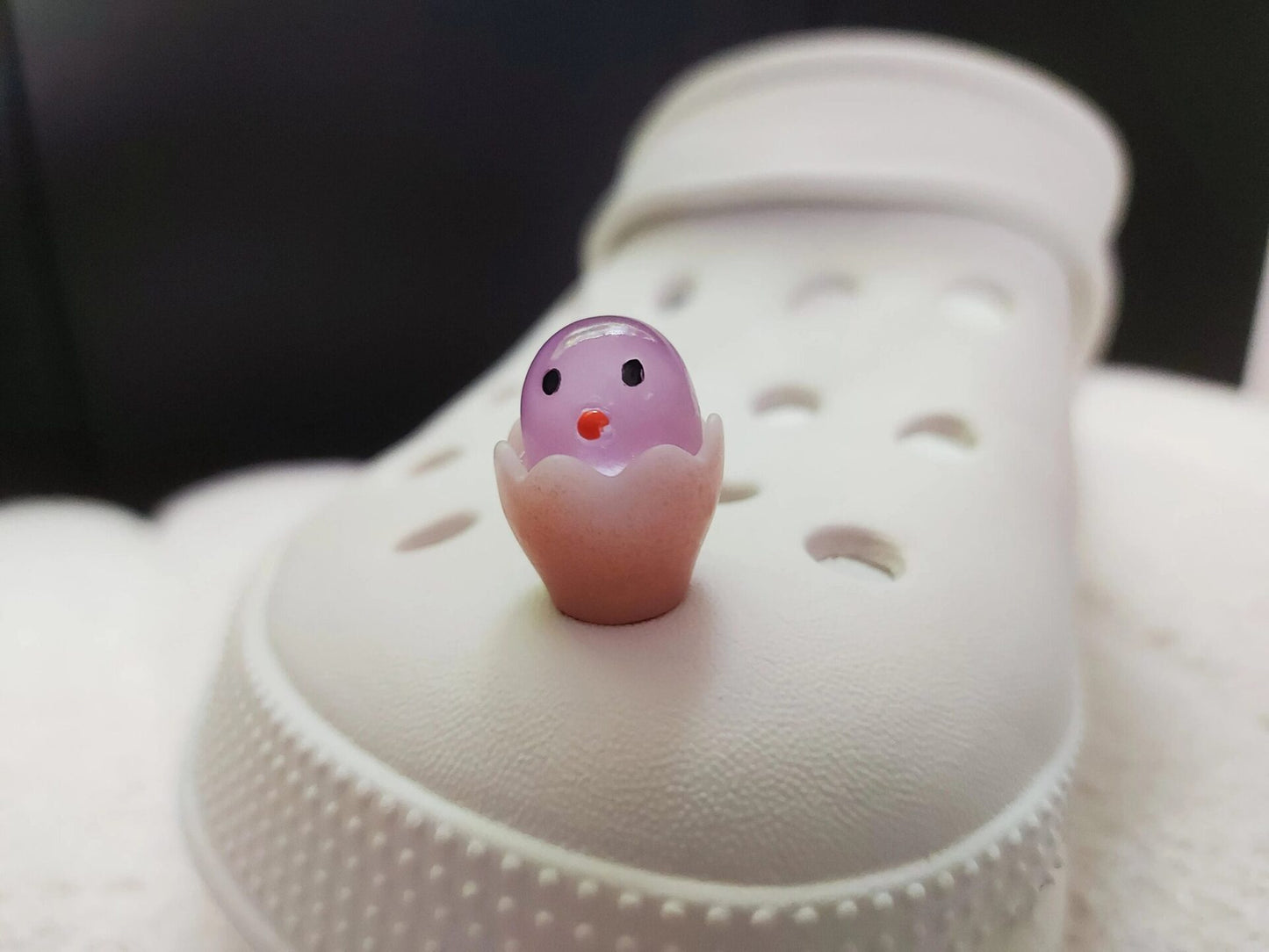 A collection of glow-in-the-dark shoe charms featuring adorable baby chicks nestled in colorful egg shells. Each charm showcases a bright chick in a variety of soft, pastel hues, perfect for adding a fun and playful glow to your shoes at night.